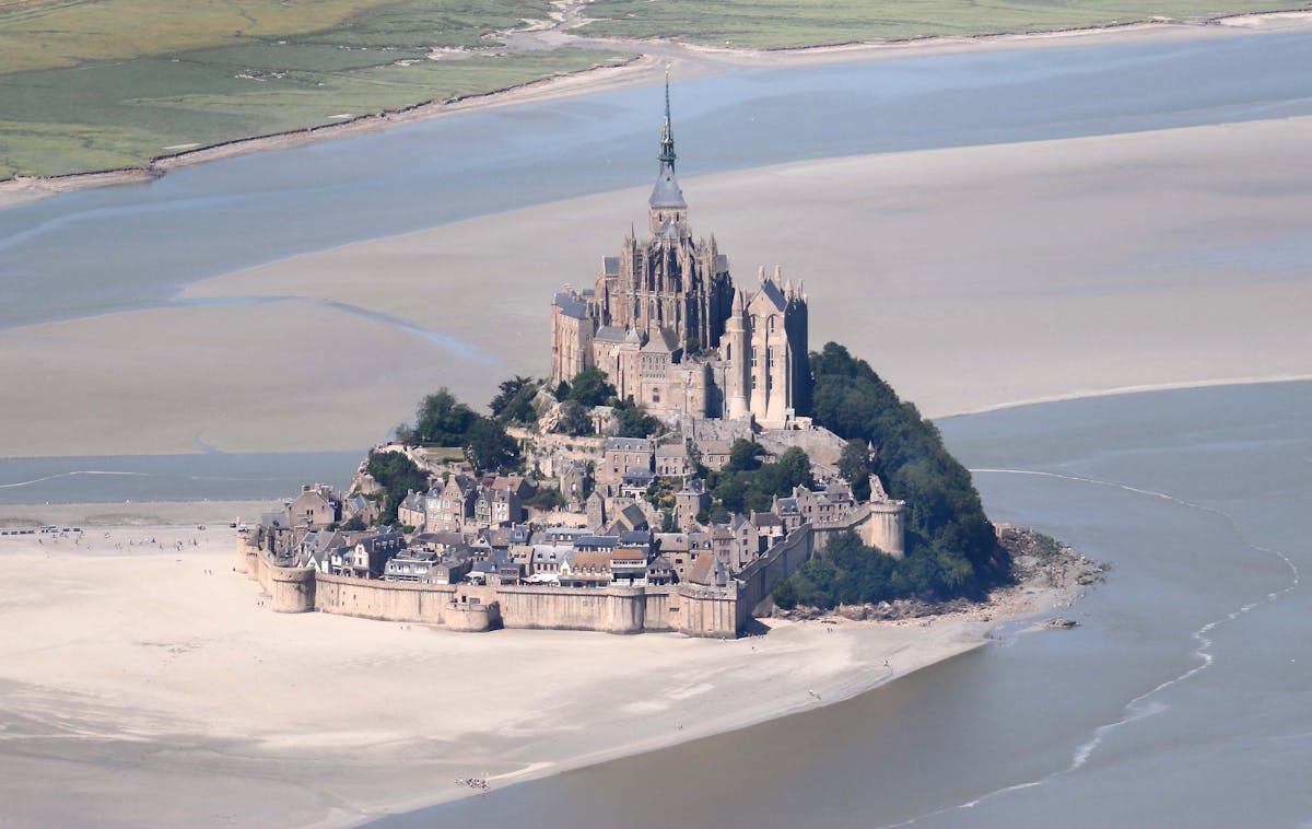 Mont Saint-Michel France at low tide showing dramatic causeway and abbey spire on tidal island
