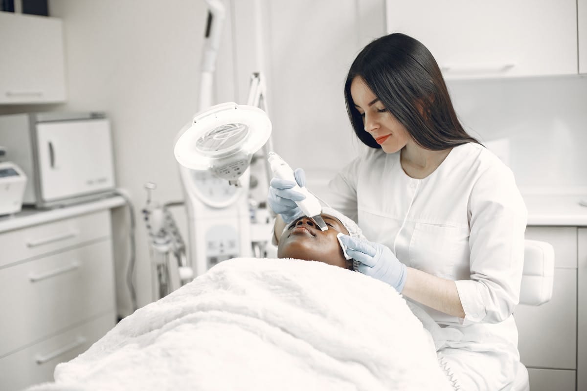 Hydrafacial vs Microdermabrasion: Choosing the Right Skin Treatment for You 2 A skilled practitioner performs a relaxing facial treatment, promoting wellness and skincare in a modern clinic.