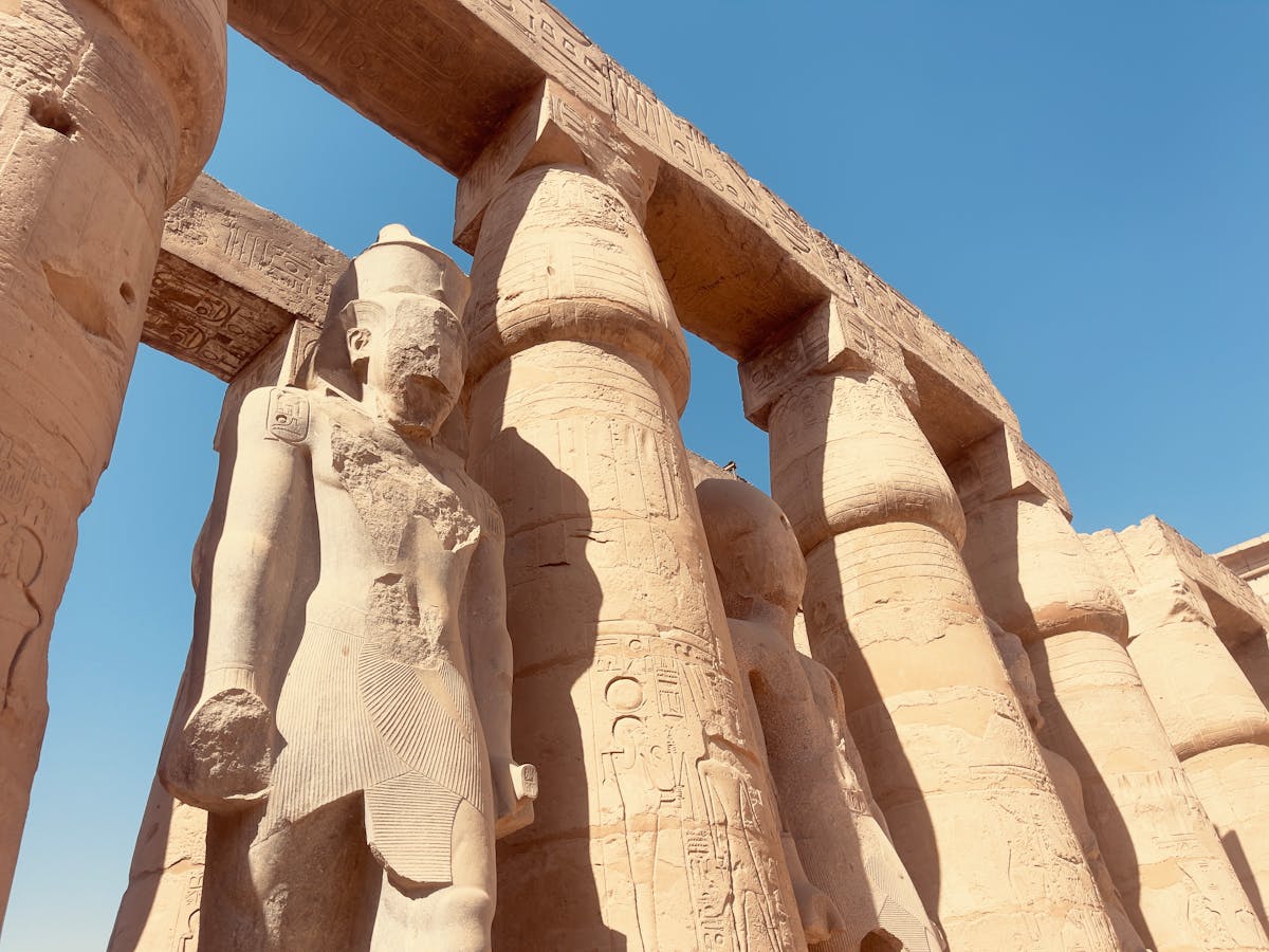 Day Trip to Luxor from Cairo: An Unforgettable Journey into Ancient Egypt 1 Majestic statues and columns at Luxor Temple under a clear blue sky.