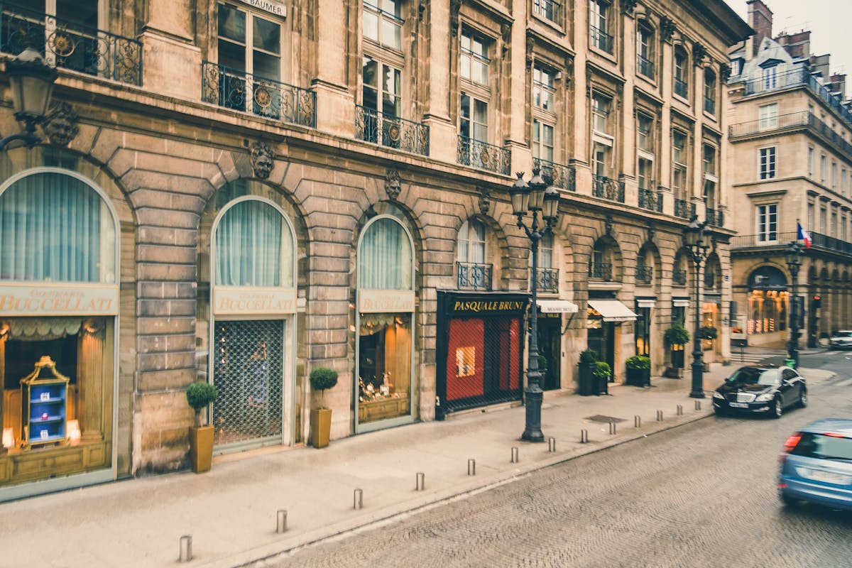 Luxury Gifts from Paris: Exquisite Finds for Every Occasion 2 Elegant Parisian street with classic architecture, cars, and boutique storefronts.