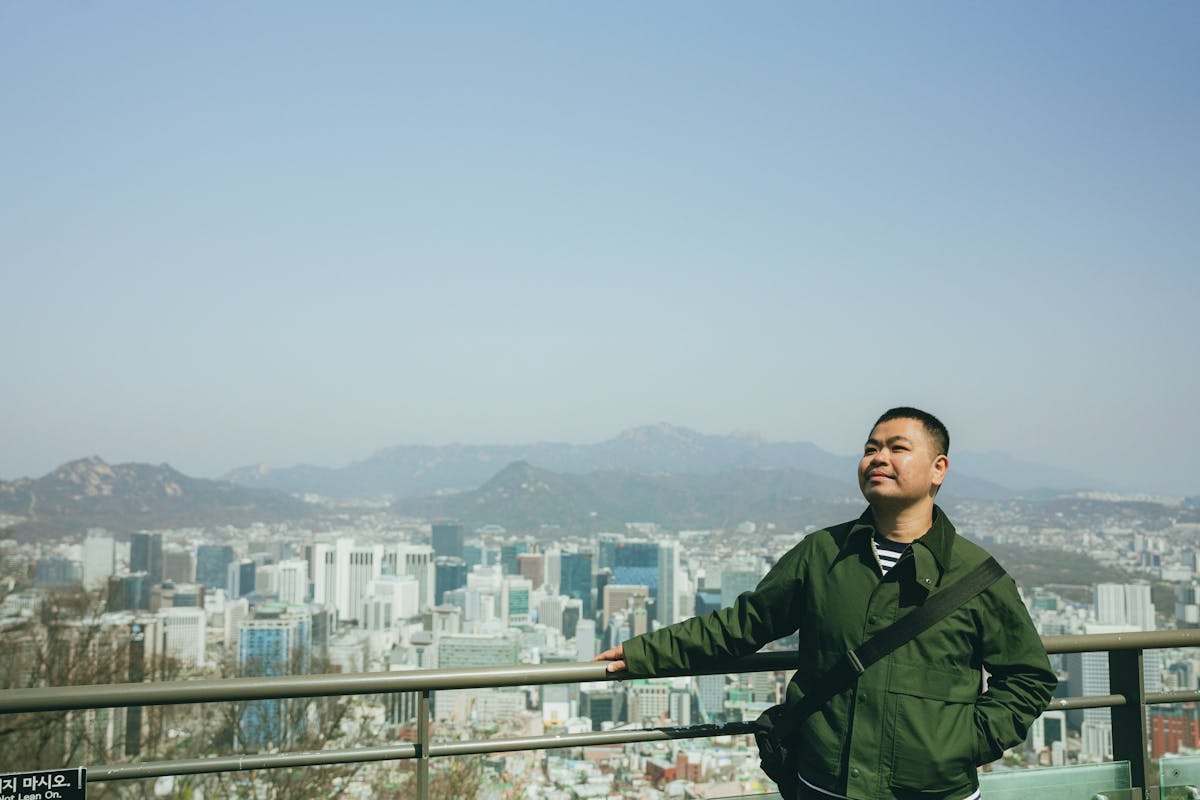 Korea Itinerary: Discover Hidden Gems in 7 Days 1 A person enjoys a panoramic view of Seoul cityscape from an outdoor observation deck in spring.