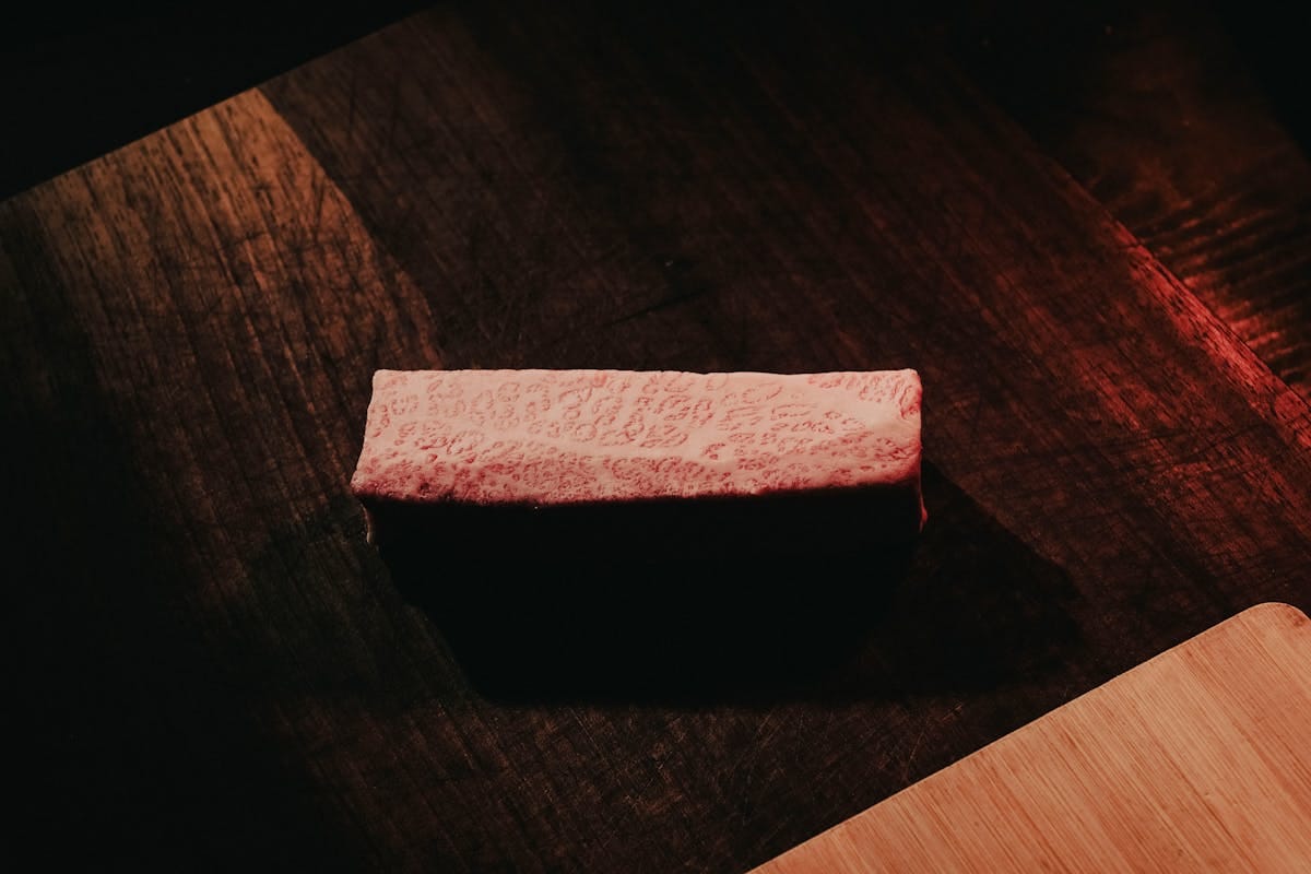 premium wagyu ribeye steak showing exceptional marbling on dark wood surface