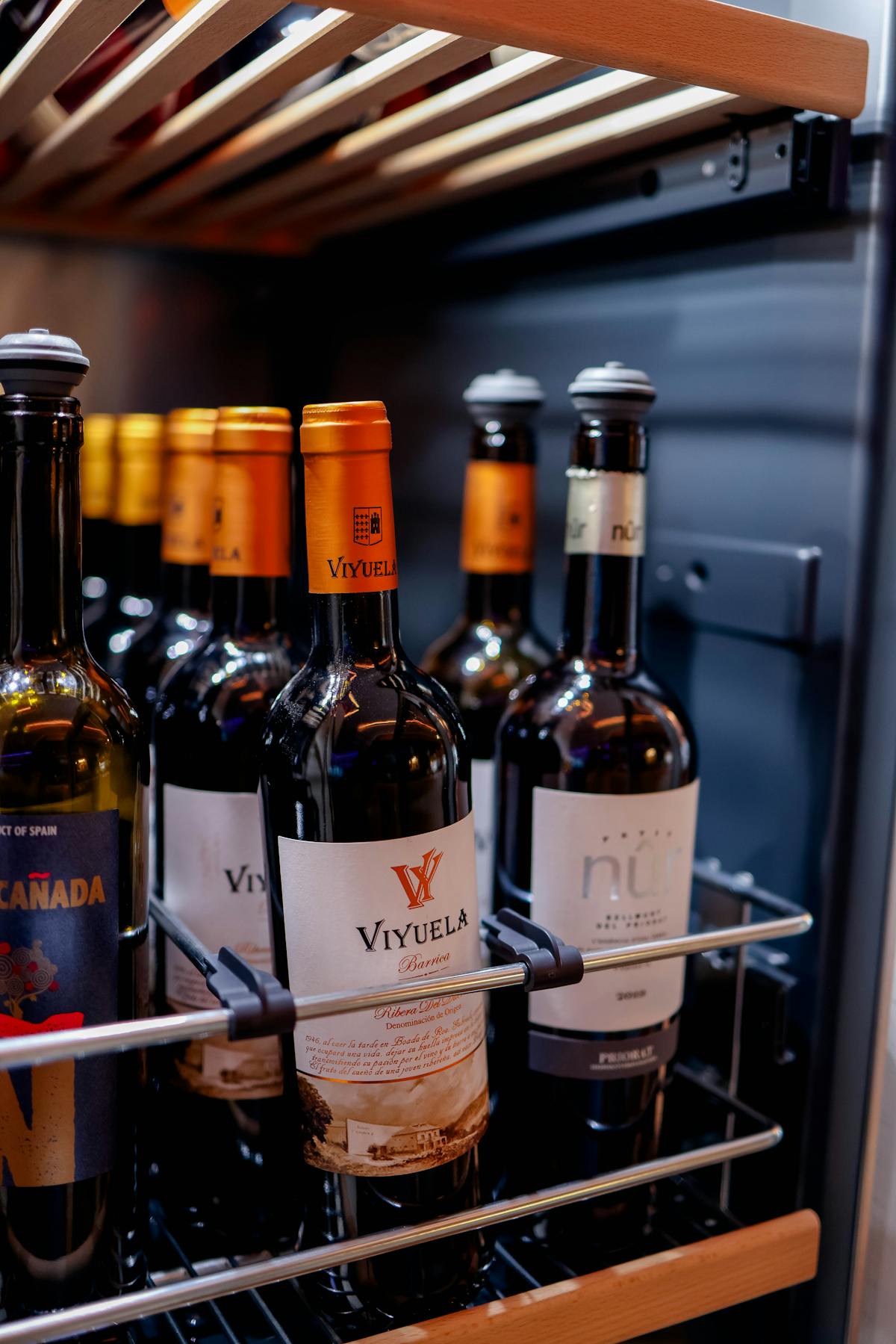 Wine bottles organized inside a wine refrigerator at optimal red wine storage temperature of 55°F