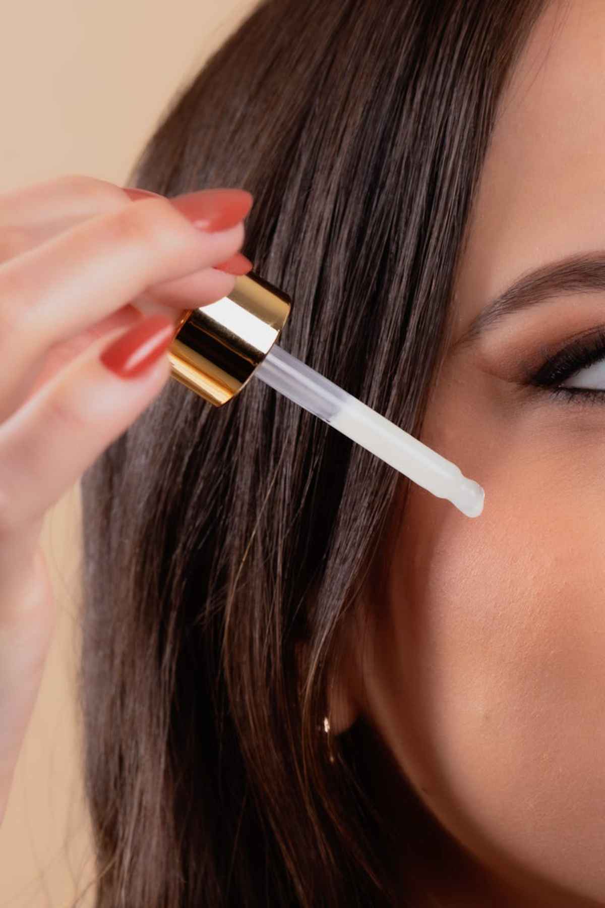 Azelaic Acid vs Retinol: Unveiling the Best for Your Skin Care Routine 5 Woman applies skincare serum using dropper for healthy skin beauty routine