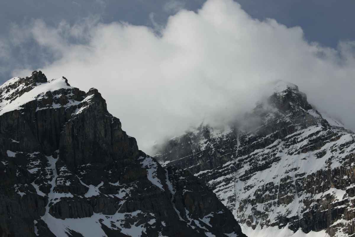 Snow-covered peaks of Jasper National Park in Alberta, Canada, under cloudy sky.