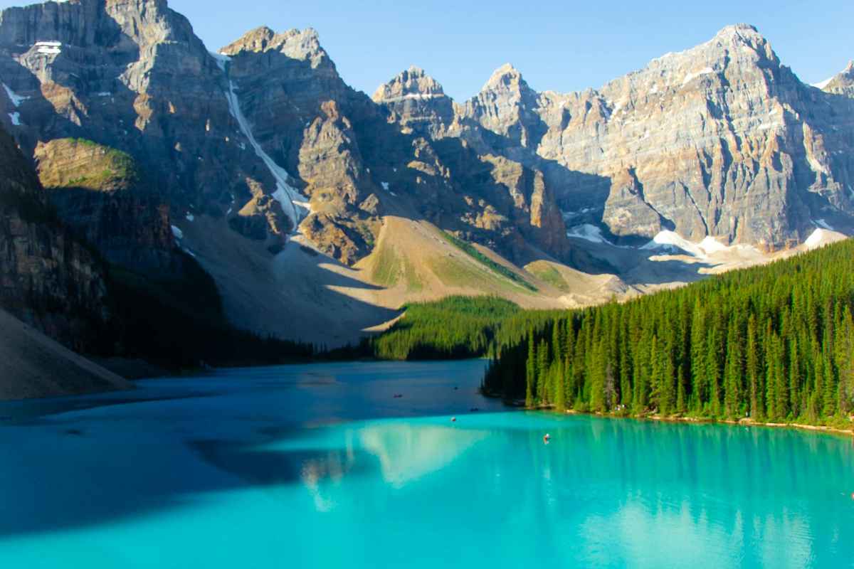 Picturesque scenery of calm turquoise water of river flowing among rocky mountains in sunny day
