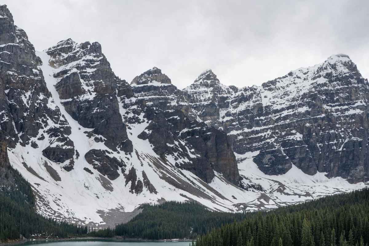 Breathtaking view of Moraine Lake bordered by towering snow-covered Rocky Mountains.