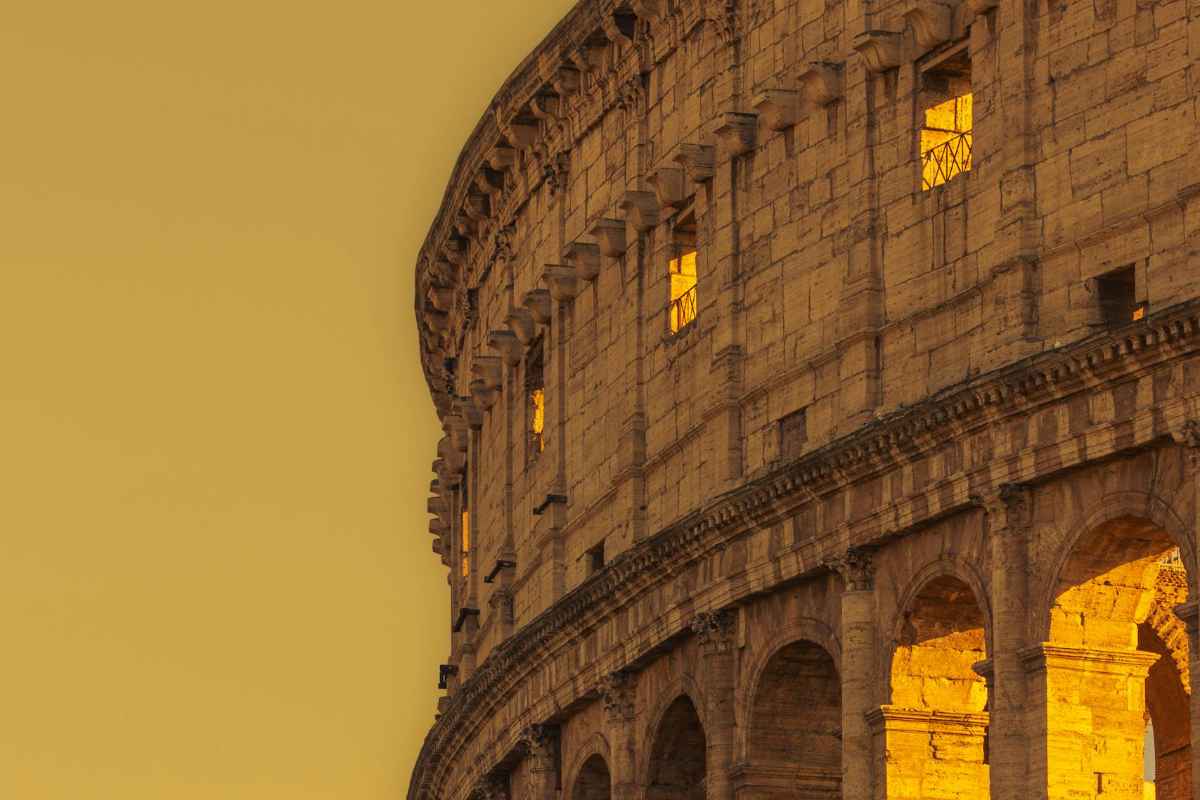 The majestic Colosseum basked in a warm golden glow during twilight in Rome, Italy.