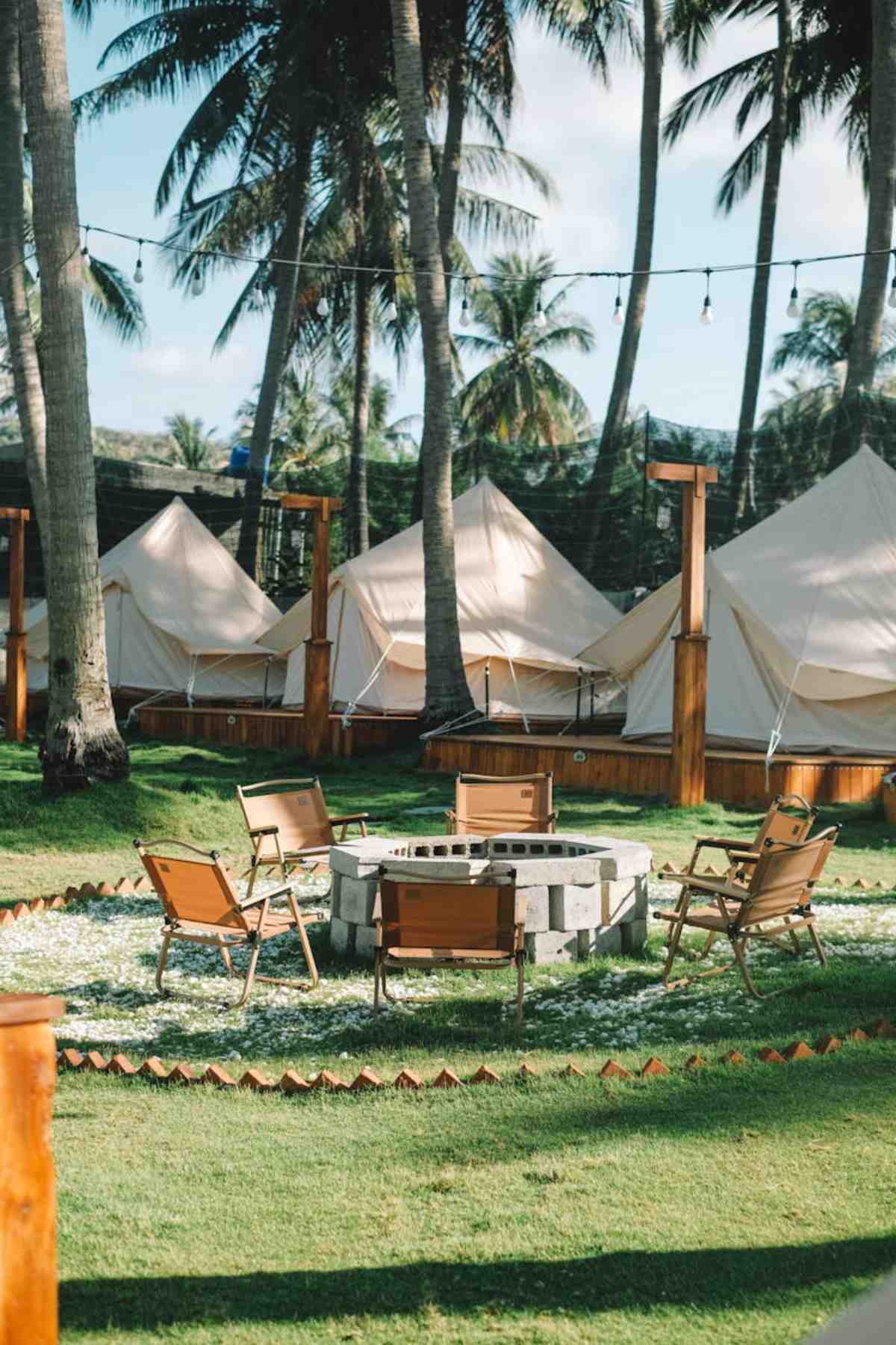 Glamping setup with chairs and fire pit in tropical setting
