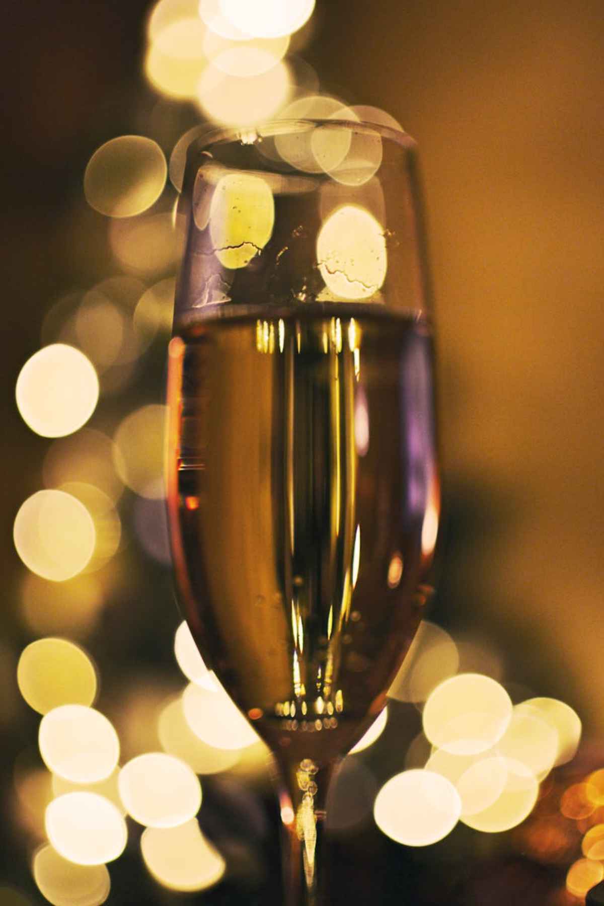 Close-up champagne glass with festive bokeh lights celebratory