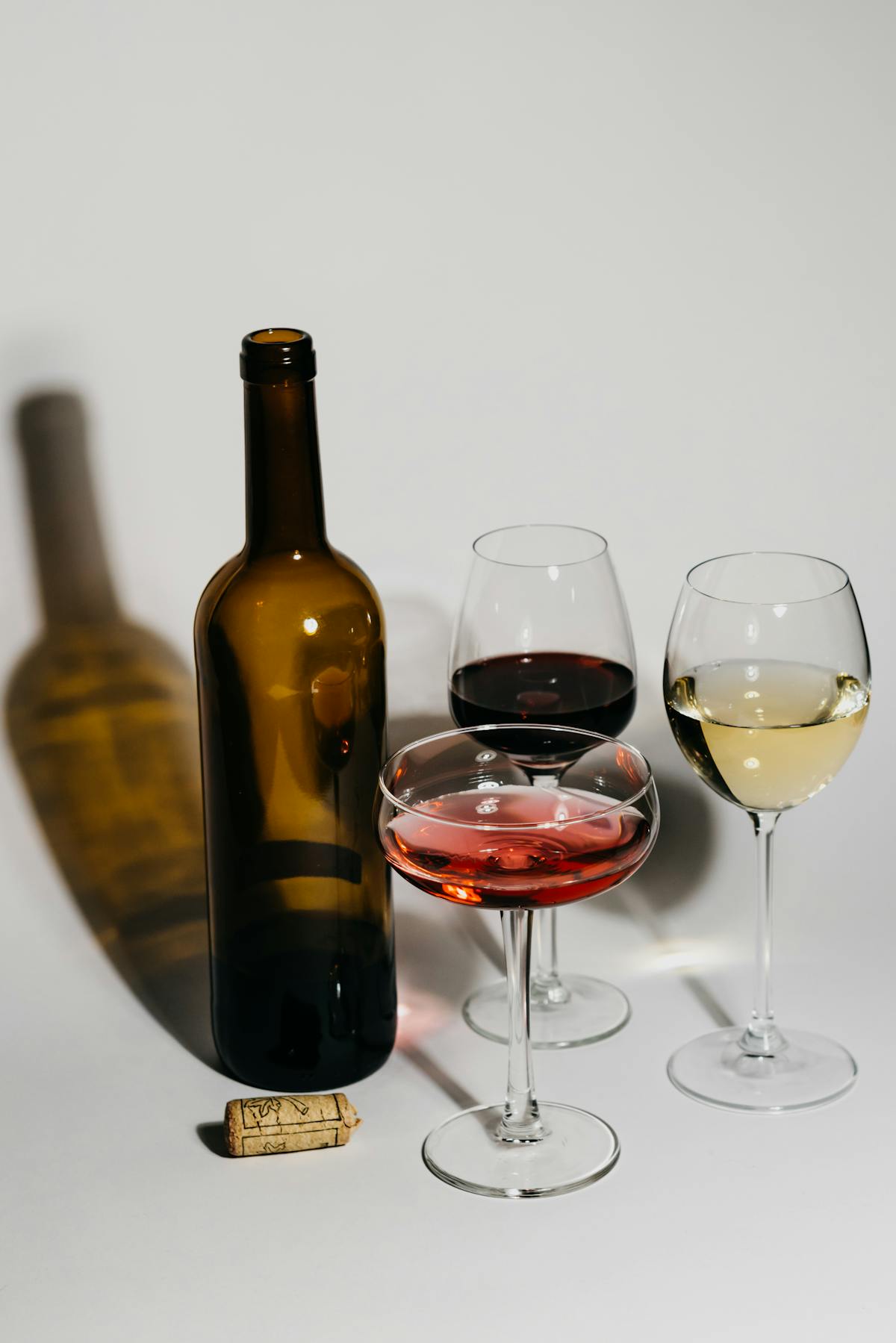 Wine bottle with glasses of red, rosé, and white wine for beginners