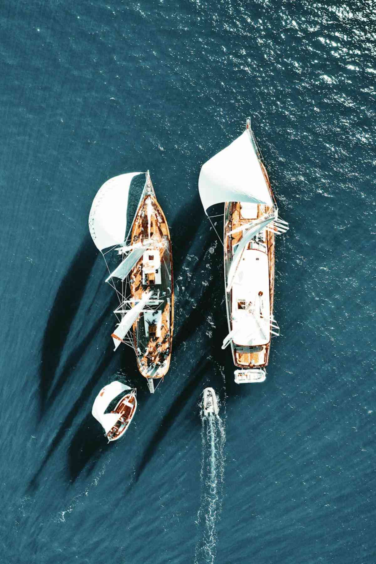 Stunning aerial view of sailboats navigating the calm open blue sea