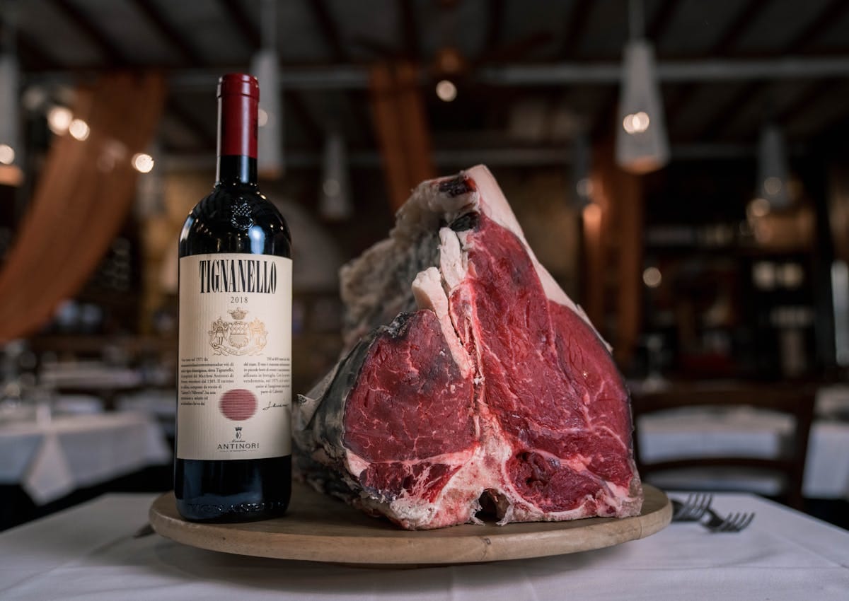 A prime cut of beef next to a bottle of Tignanello red wine, representing the classic Cabernet Sauvignon and steak food pairing