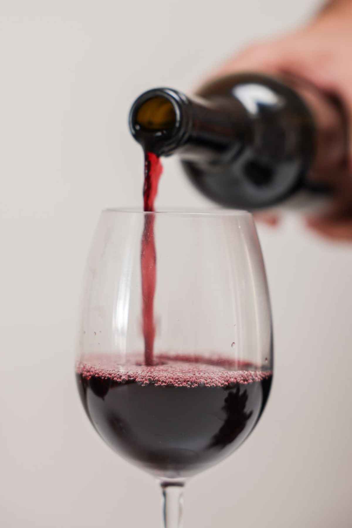 Close-up red wine being poured into a glass wine tasting
