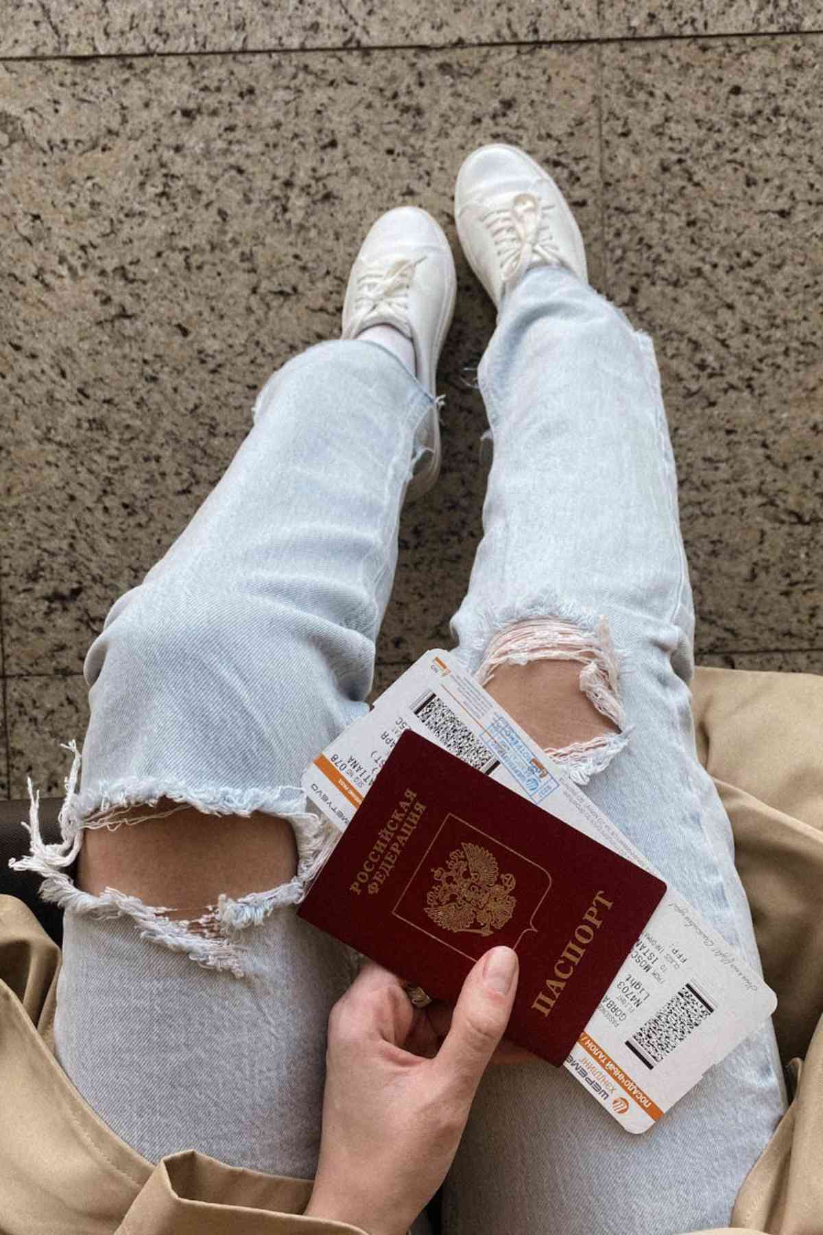 Can You Bring a Camera on a Plane: Guidelines for Travel Photographers 2 Person holding passport and boarding passes travel airport