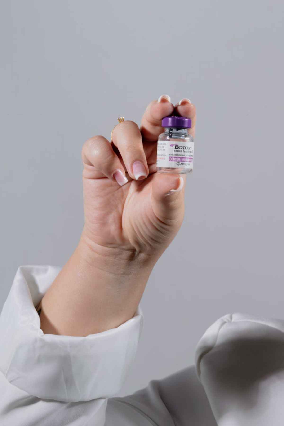 Close-up of a hand holding a Botox vial for healthcare
