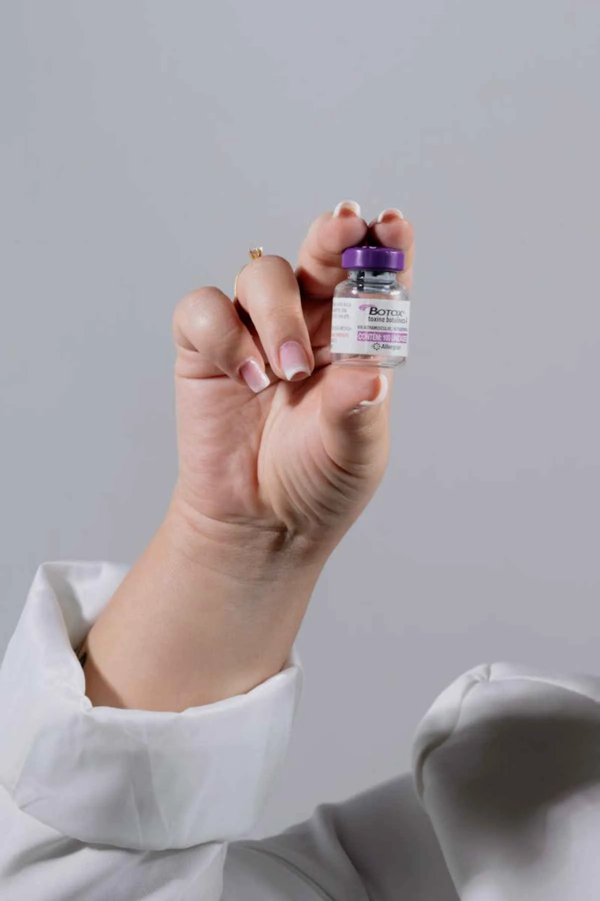 Close-up of a hand holding a Botox vial for healthcare