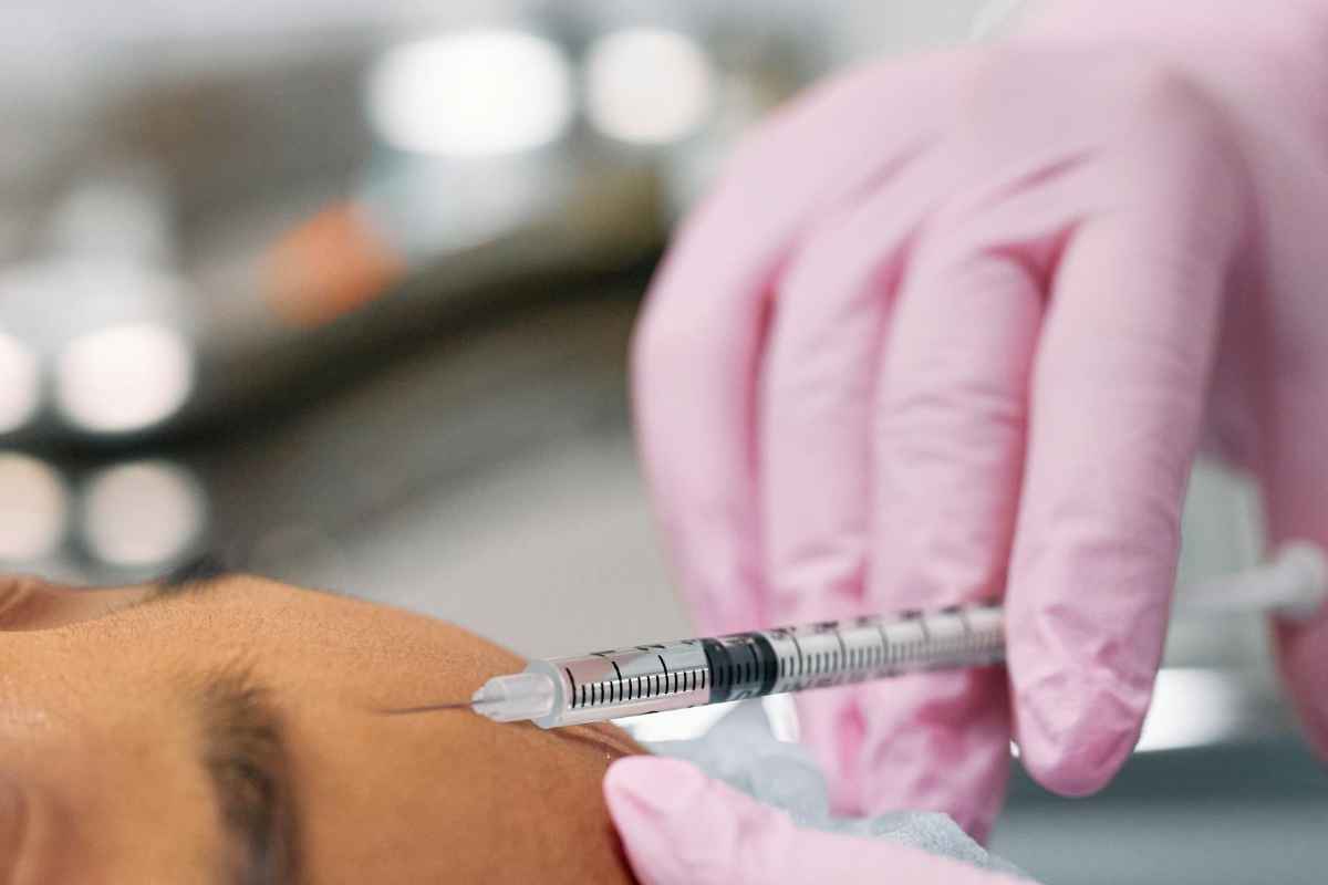 Detailed view of a cosmetic injection procedure being performed in a clinical setting.