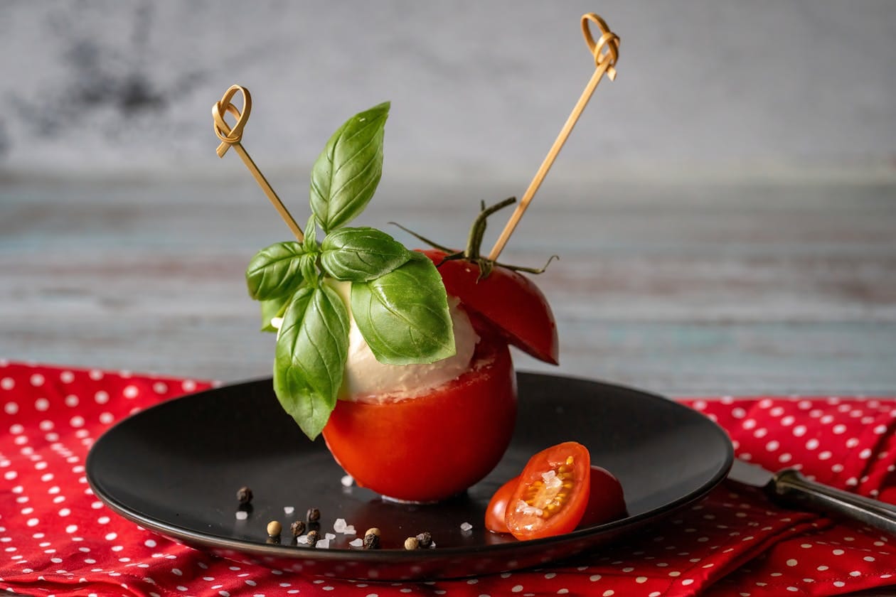 Fresh mozzarella balls, cherry tomatoes and basil leaves for caprese skewers on an elegant plate