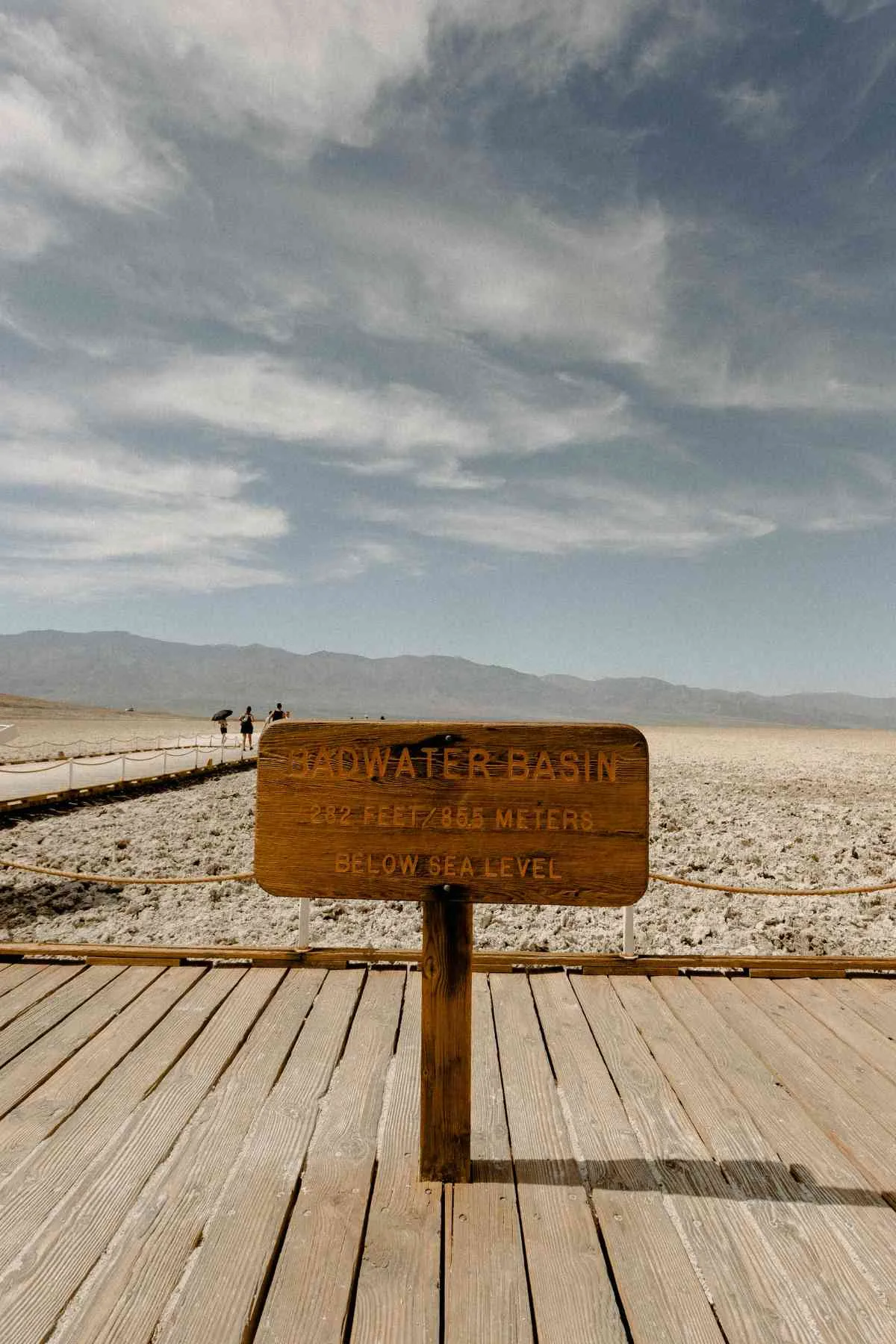 Wooden sign at Badwater Basin, Death Valley, marking elevation below sea level under a clear sky.