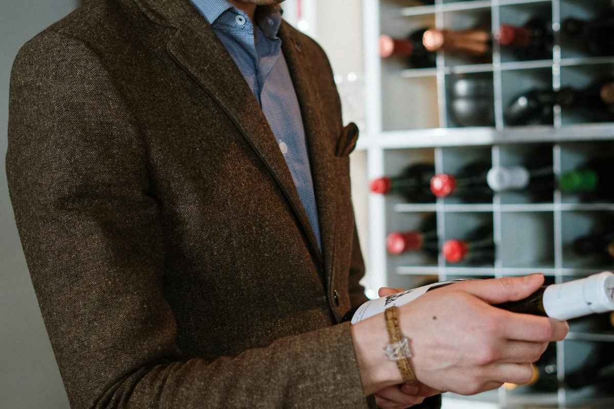9 Best Denmark Wineries: Cool-Climate Nordic Wine Country Guide 1 A sommelier examines a wine bottle in a contemporary wine cellar with a diverse wine collection.
