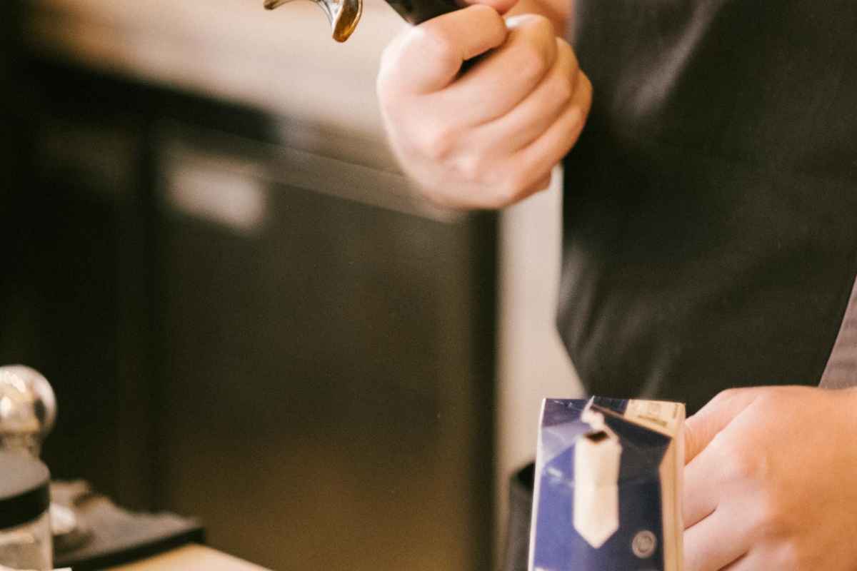 Espresso Bitter vs Sour: What's the Difference and How to Fix It (2026) 1 Barista holding a portafilter preparing coffee in a cozy café environment.