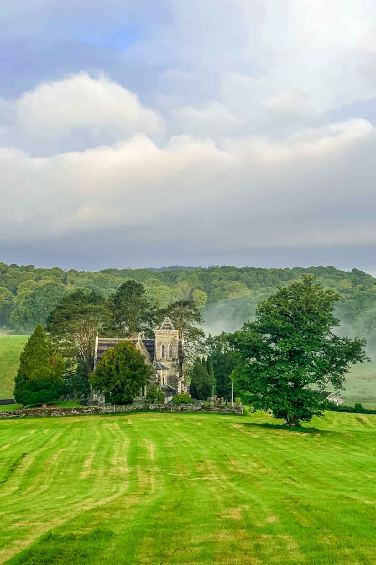 Serene view of an ancient church surrounded by lush greenery in Near Sawrey England