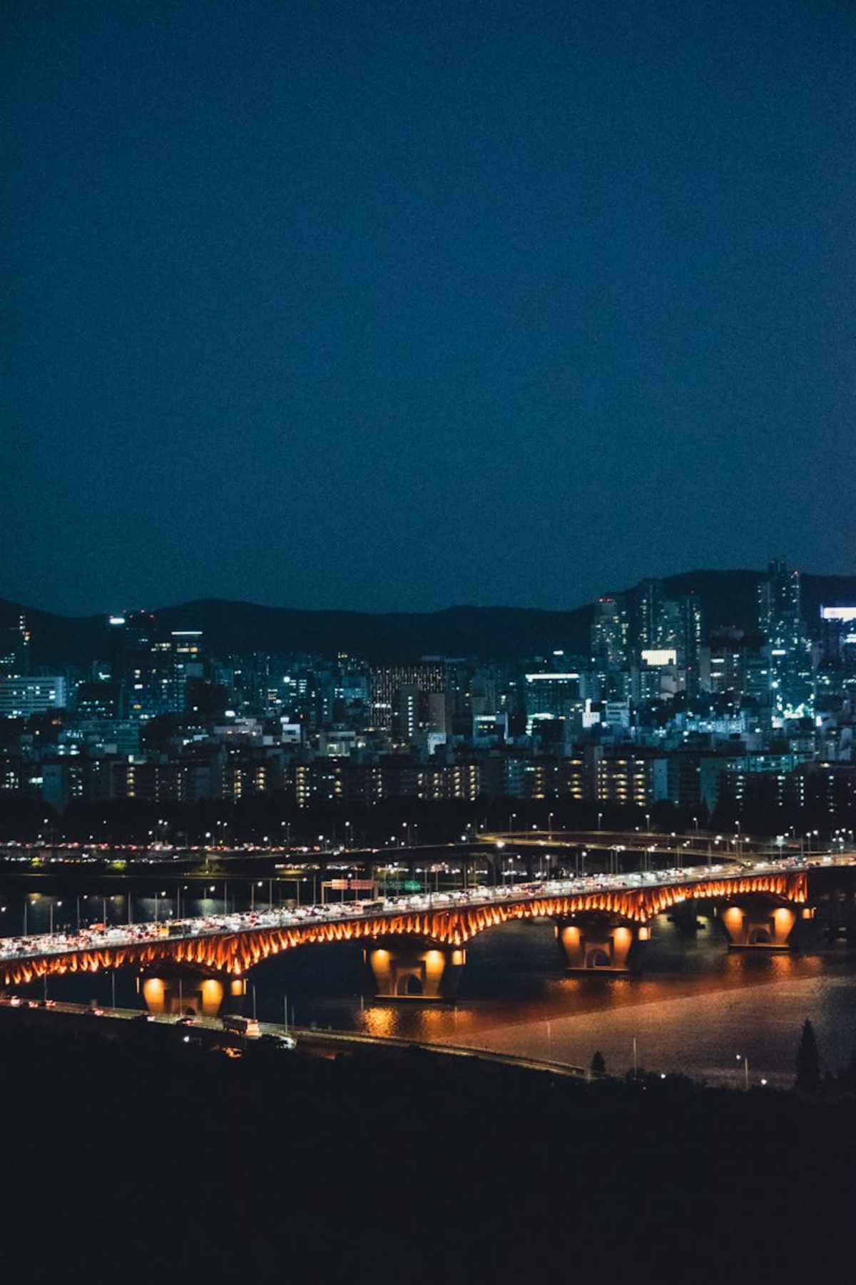 Night view of Seoul with illuminated bridge and river reflecting city lights