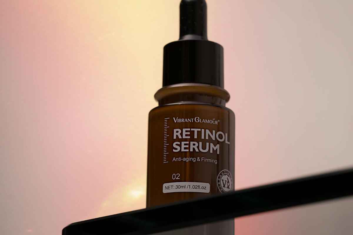Lactic Acid vs. Retinol: Skincare Secrets for Travelers 1 A retinol serum bottle on a glass shelf with a warm gradient backdrop.