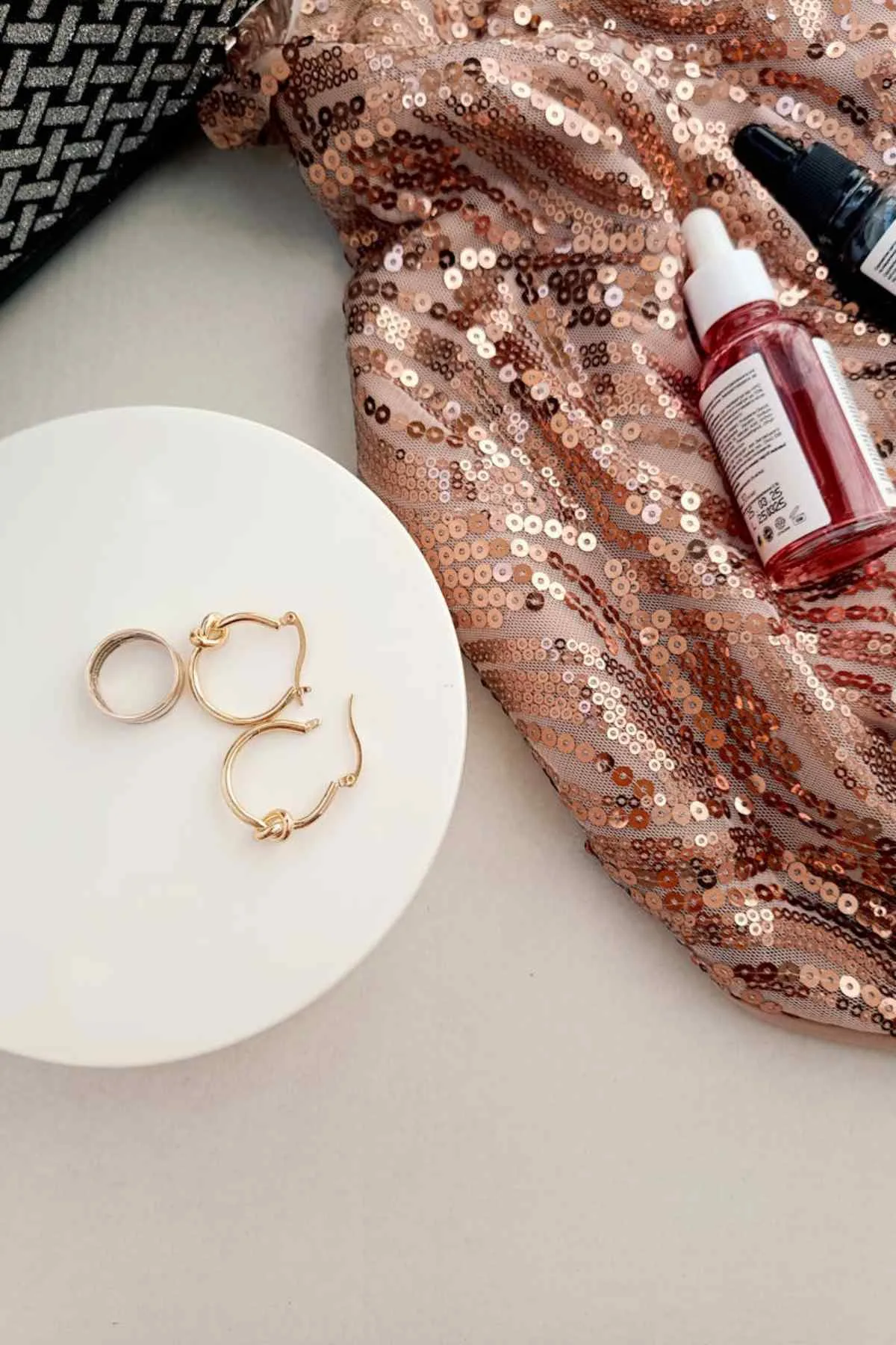 Gold jewelry with sequin fabric and skincare products elegant