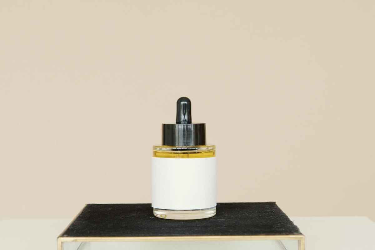 Elegant skincare product on a black stand against a neutral background.