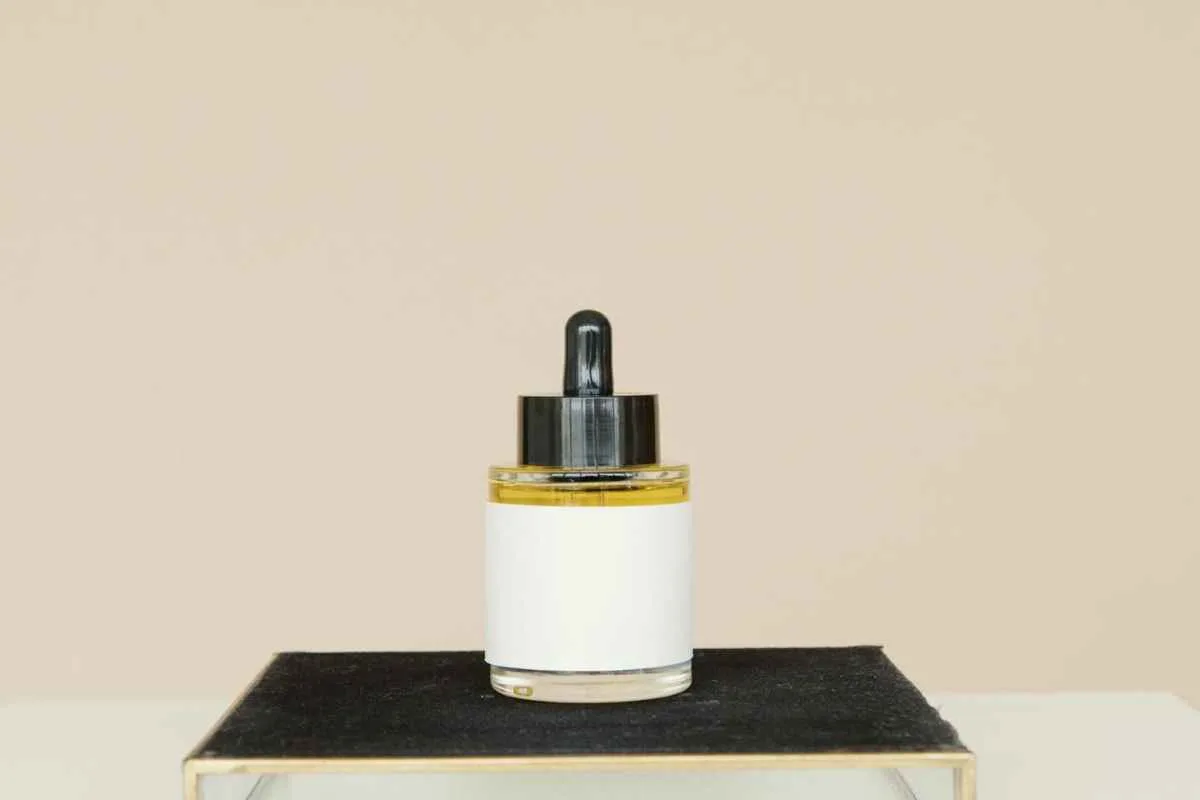 Skincare Acids Guide: Lactic Acid vs Salicylic Acid 1 Elegant skincare product on a black stand against a neutral background.