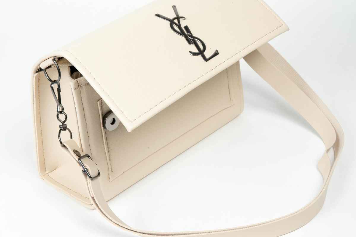Stylish white leather handbag featuring luxury design and chain detail.