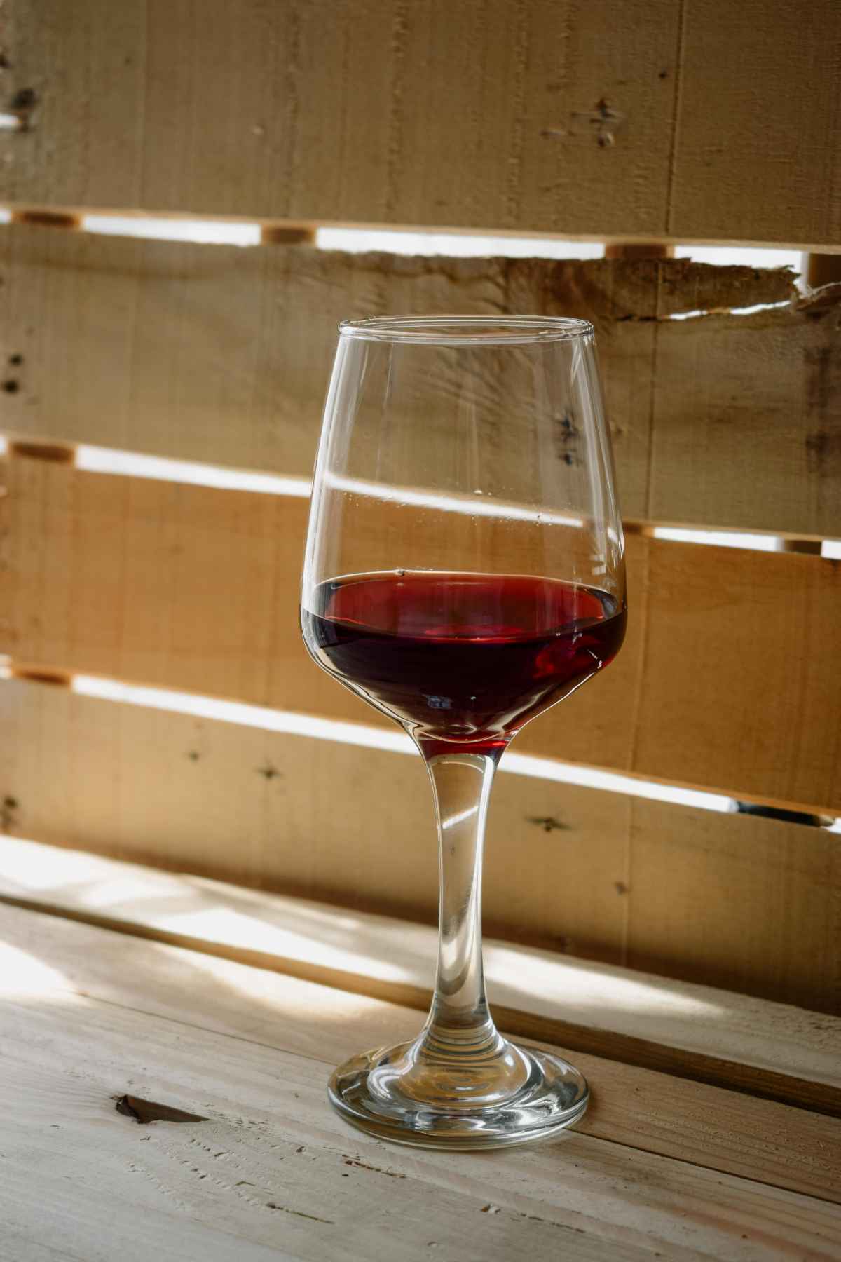 Bold red wine glass on wooden background Malbec Cabernet Sauvignon tasting