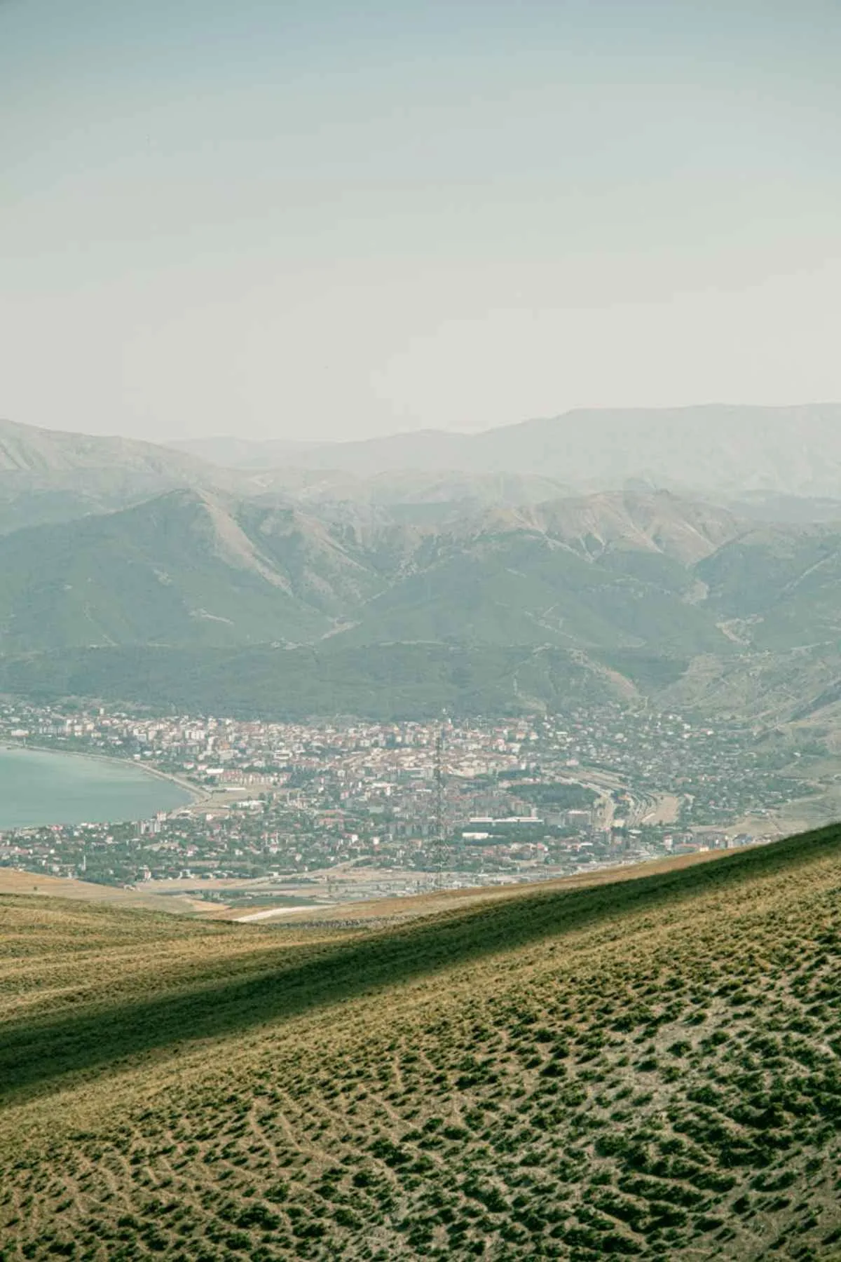 Scenic view of a town surrounded by mountains clear summer sky
