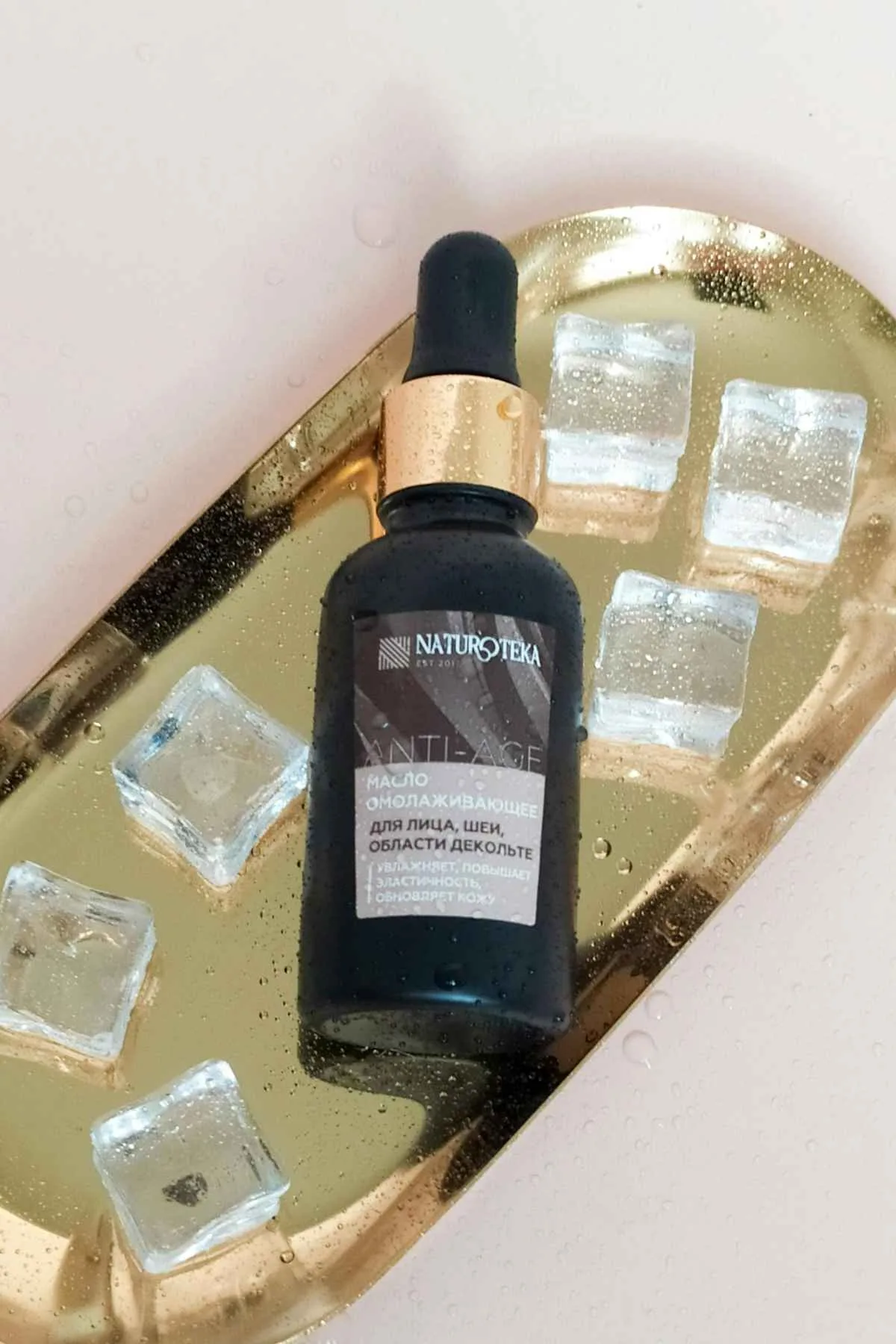 Peptides vs Retinol: Comparing Skincare Powerhouses 9 Close-up of a revitalizing serum bottle on a gold tray with ice cubes, conveying luxury skincare.