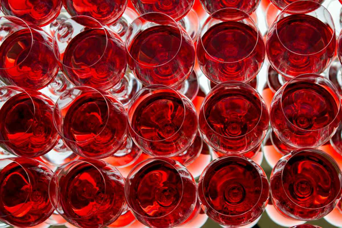 A captivating top-down view of multiple red wine glasses with a striking mirror reflection.