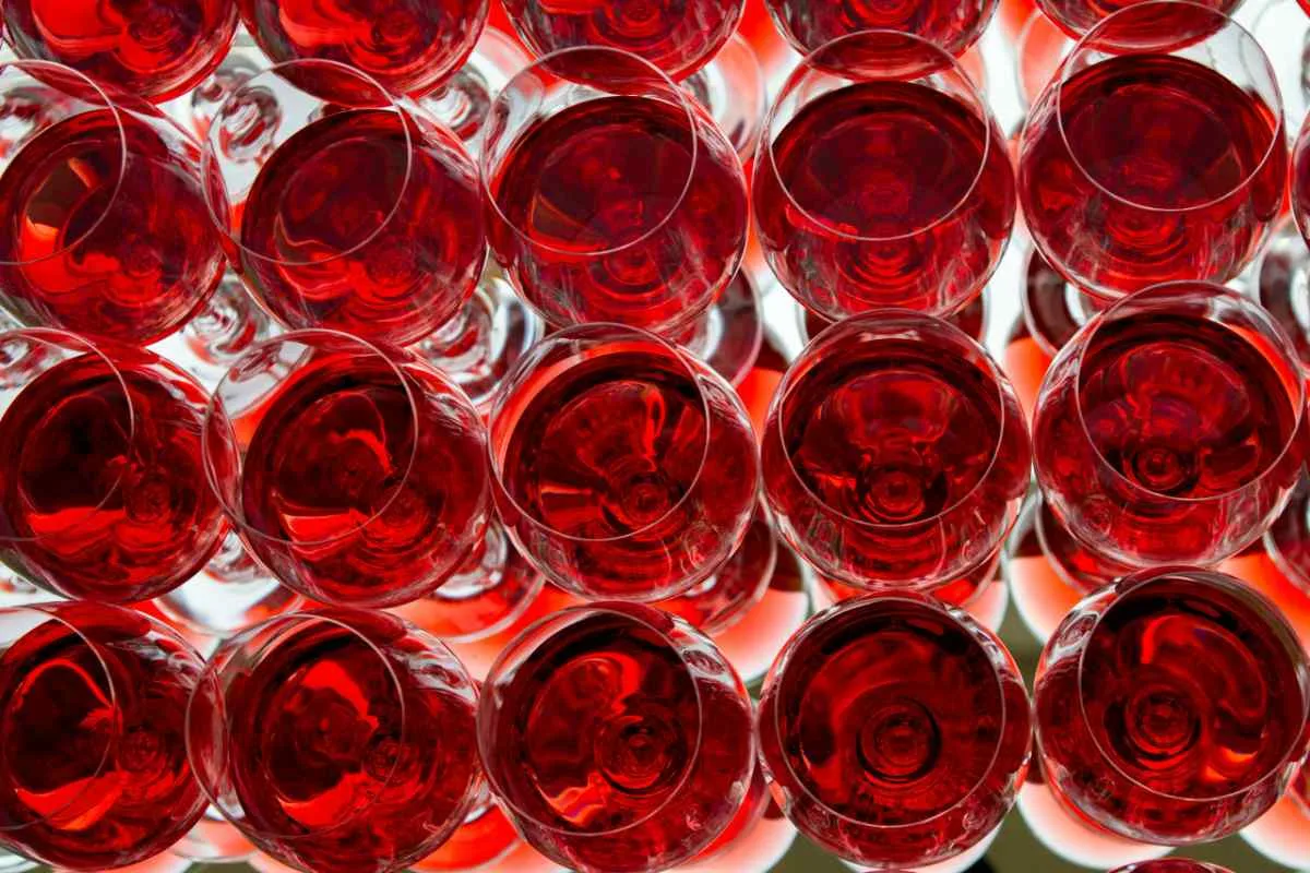 A captivating top-down view of multiple red wine glasses with a striking mirror reflection.