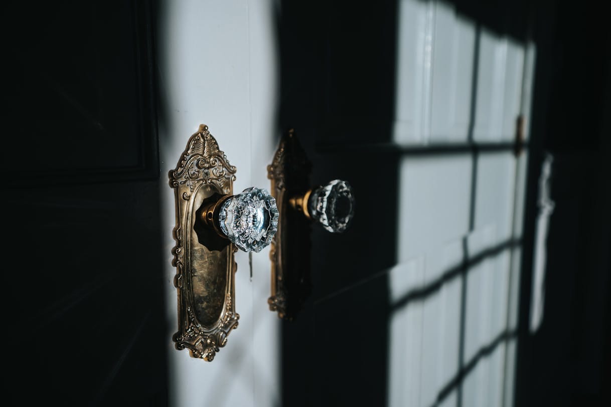 Close-up of an ornate antique brass door knob and plate showing the quality hardware upgrade that elevates quiet luxury interiors
