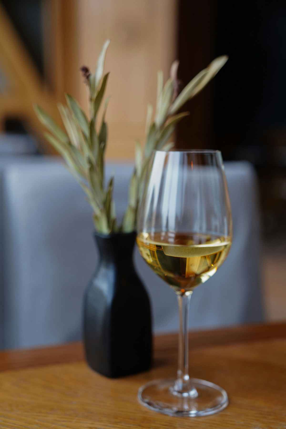 Sauvignon blanc white wine glass on restaurant table with vase