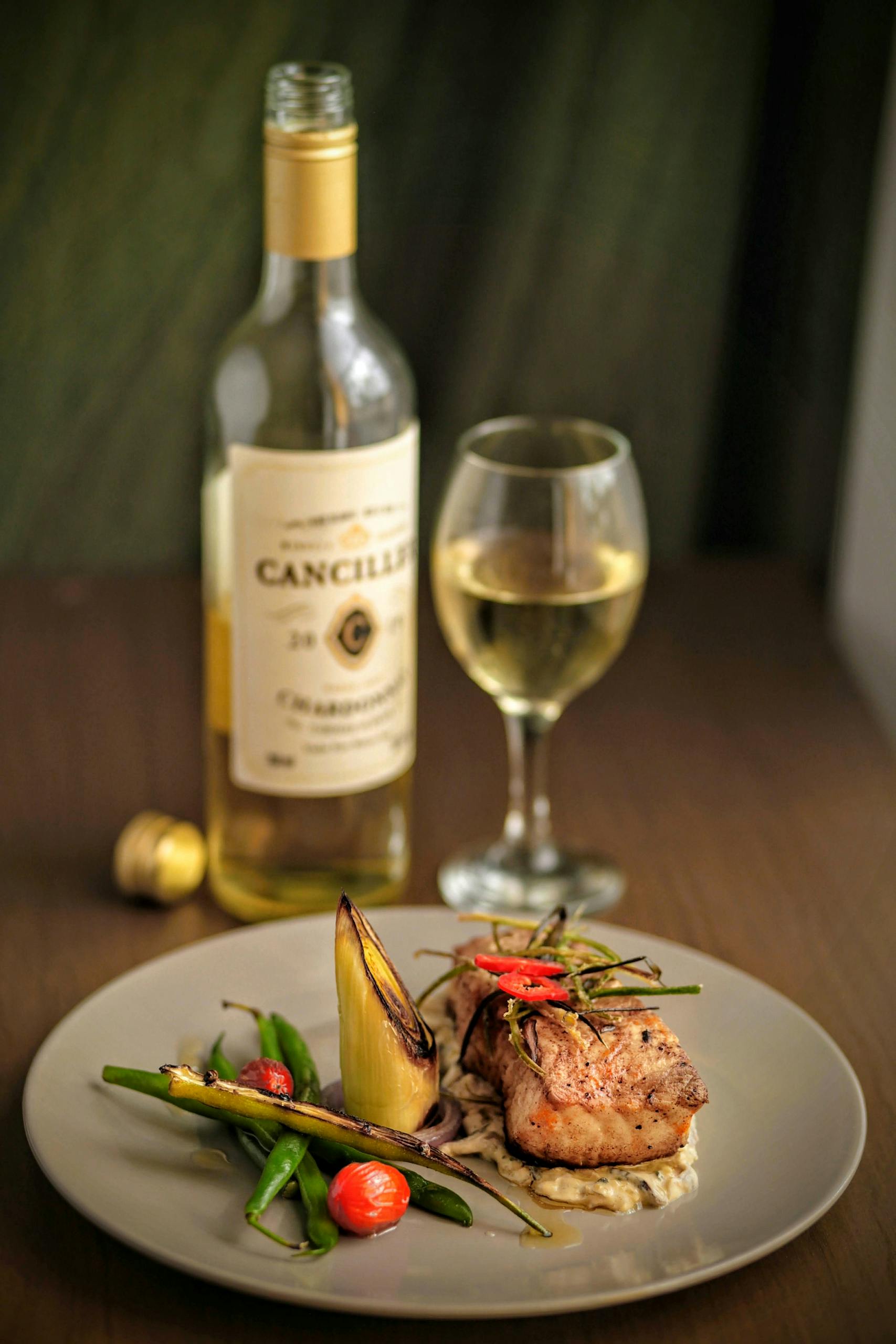 Savor a gourmet seafood dish paired with white wine in a Porto restaurant, showcasing fine dining in Portugal.