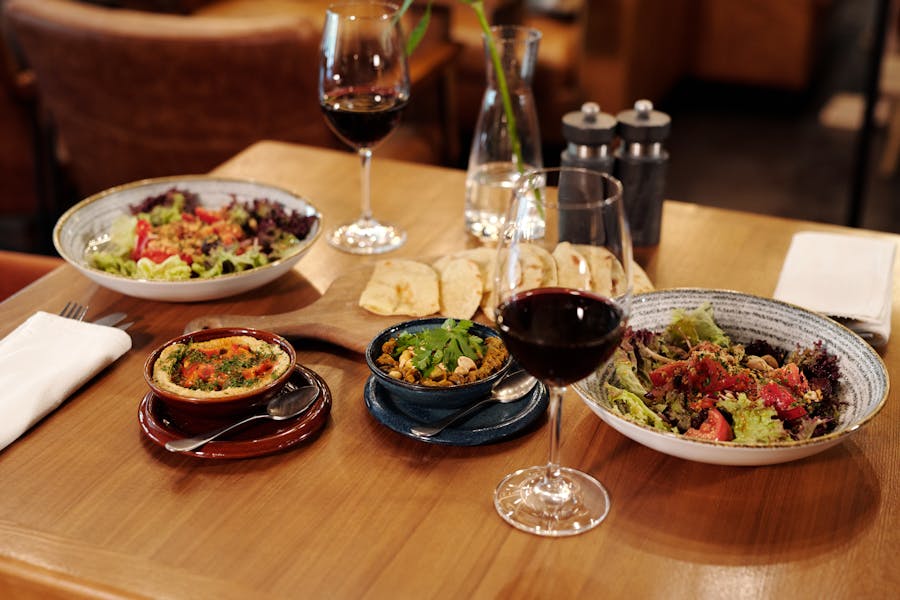 Beautifully arranged Mediterranean dining table with wine glasses and assorted dishes showing the art of wine and food pairing