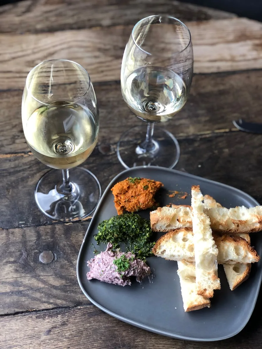 A Simple Guide to Wine and Food Pairing Rules (And When to Break Them) 10 A rustic charcuterie platter with breadsticks and white wine glasses on a wooden table, illustrating wine and food pairing