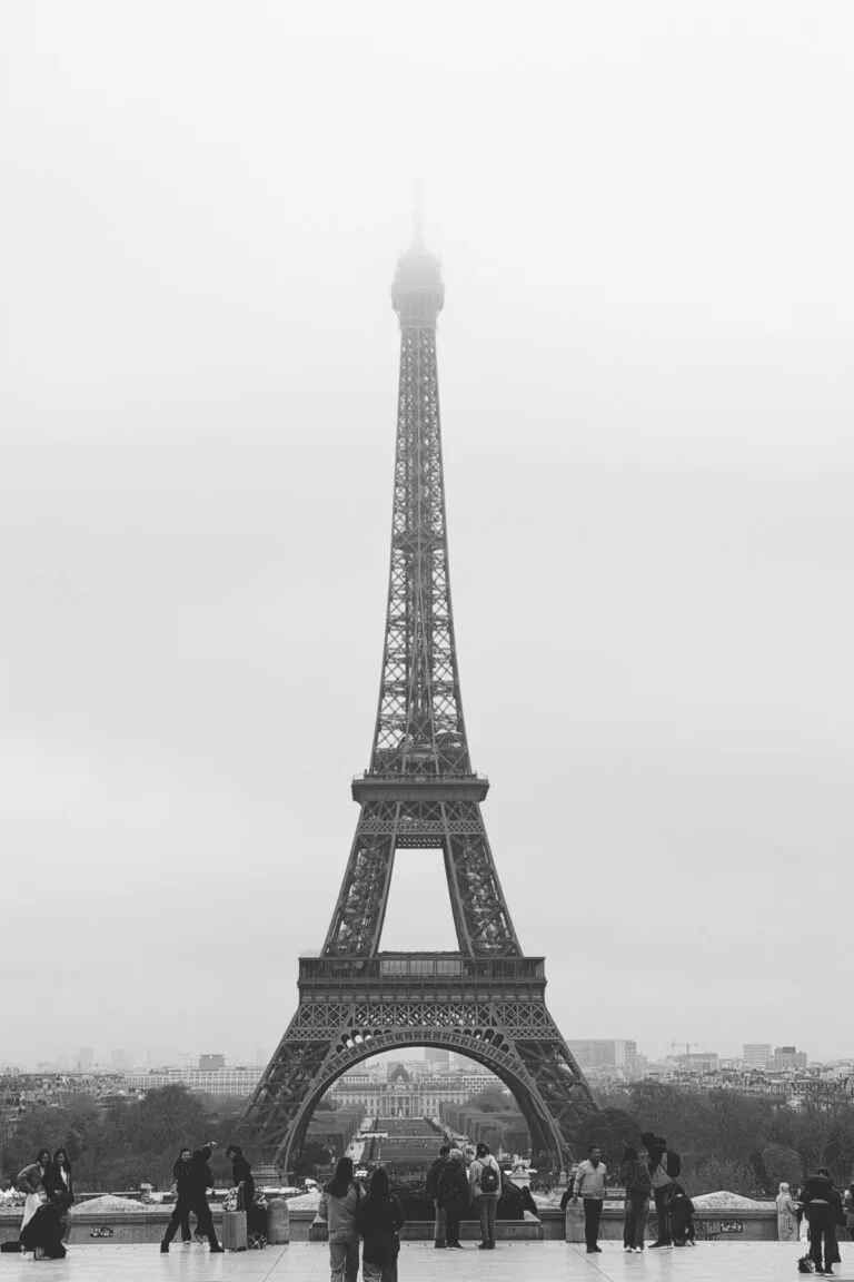 Home 14 Black and white photo of the Eiffel Tower in fog with visitors on a terrace in Paris