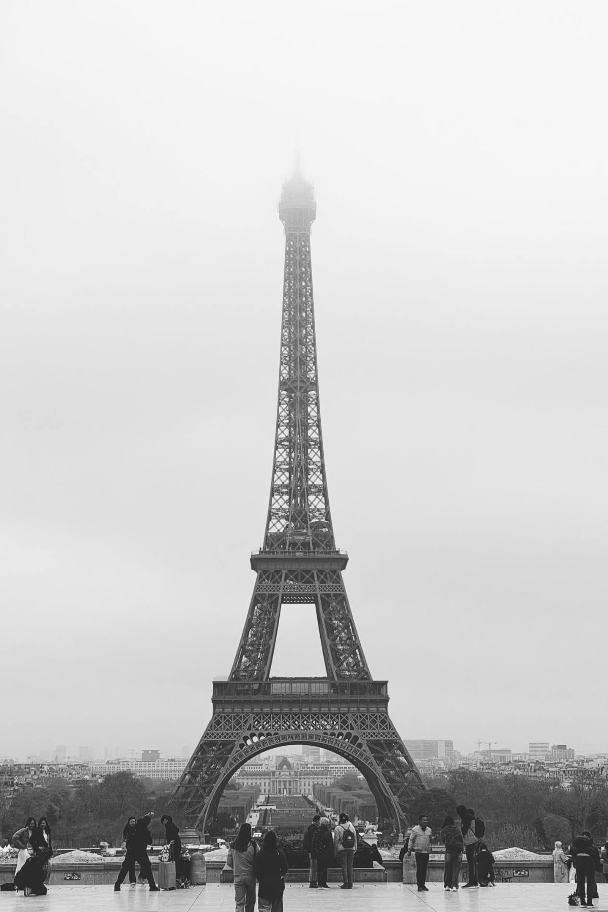 Luxury Gifts from Paris: Exquisite Finds for Every Occasion 10 Black and white photo of the Eiffel Tower in fog with visitors on a terrace in Paris