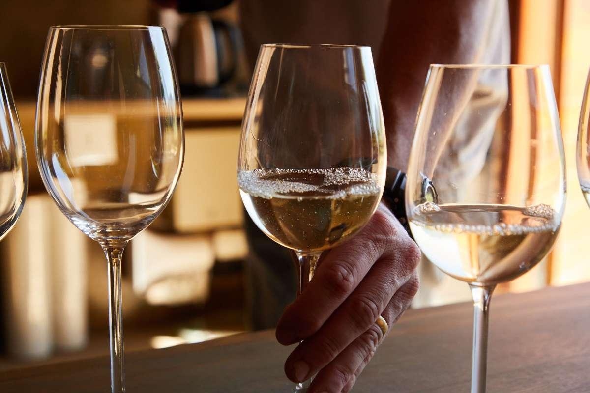 Types of Wine: 5 Main Styles You Need to Know First 2 Glasses of white wine lined up on a wooden bar during a tasting