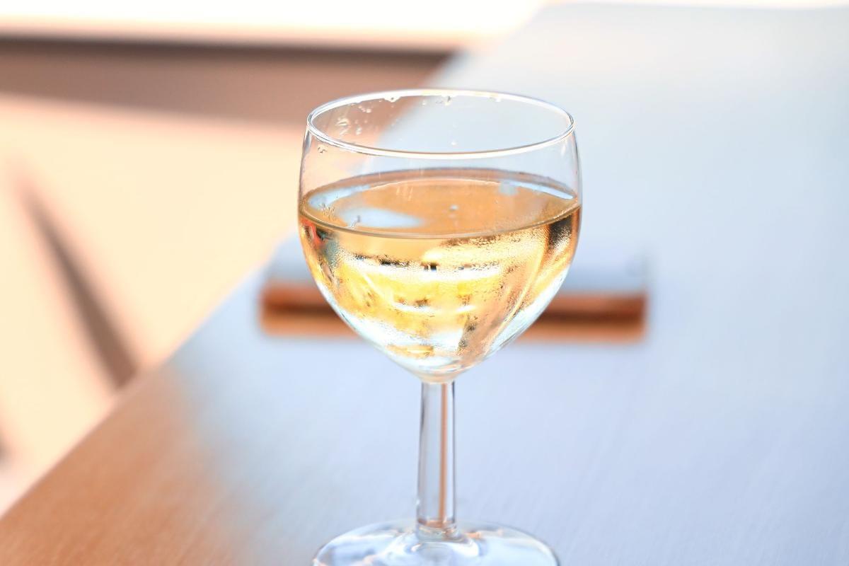 Sugar in White Wine vs Red Wine: Essential Guide to 5 Wine Types 2 Glass of chilled white wine on a wooden table with soft focus background