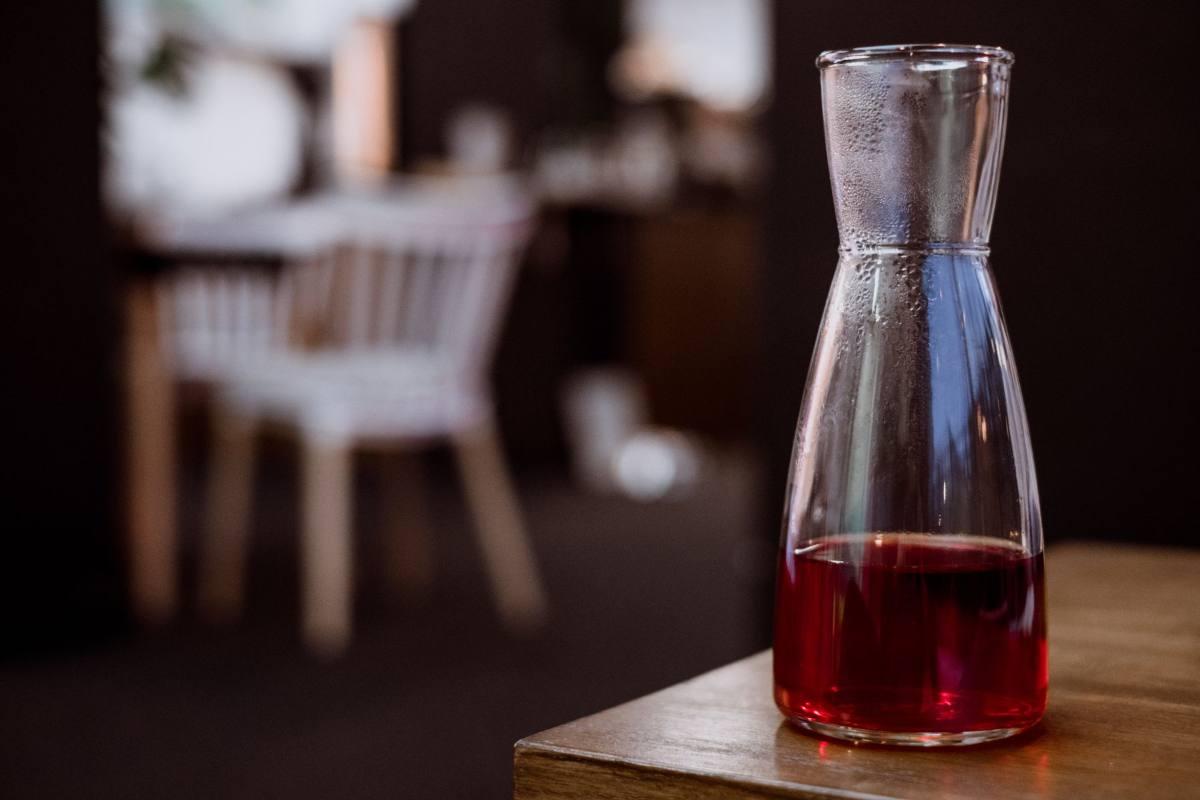 Gifts for Wine Lovers: 24 Picks Priced for 2026 1 Glass carafe of red wine on a wooden table in a dim restaurant