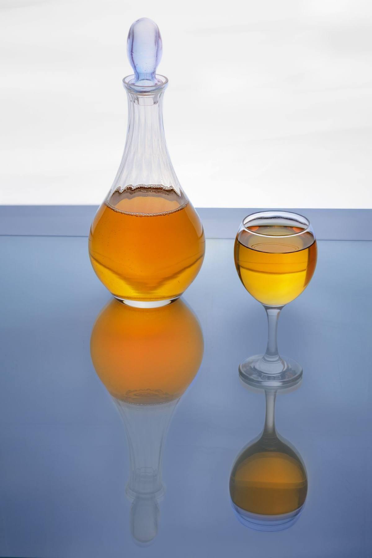 Gifts for Wine Lovers: 24 Picks Priced for 2026 1 Glass decanter and wine glass of golden wine on a reflective blue surface